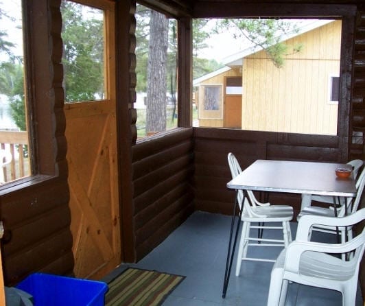 Cabin enclosed patio with table and chairs.